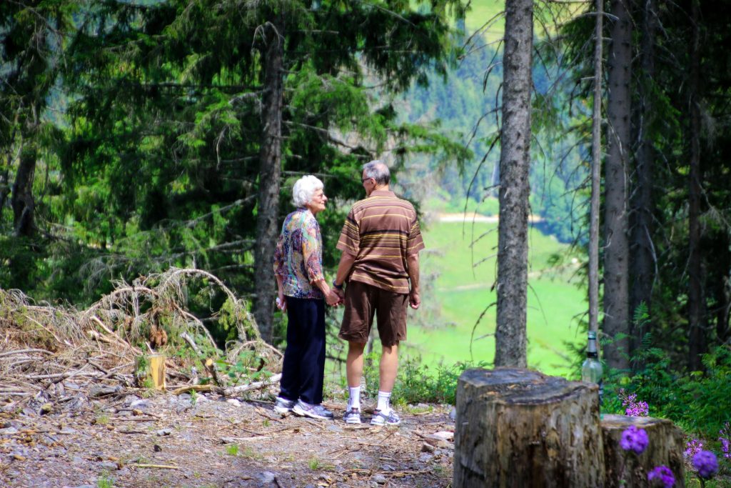 Adultos mayores agarrados de la mano en el bosque. Pañales para adultos.